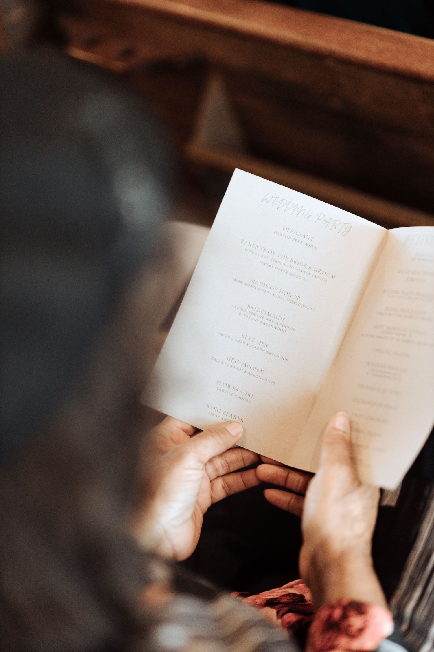 Hands holding an open book with blurred pages in a dark moody setting, creating a cinematic reading atmosphere.