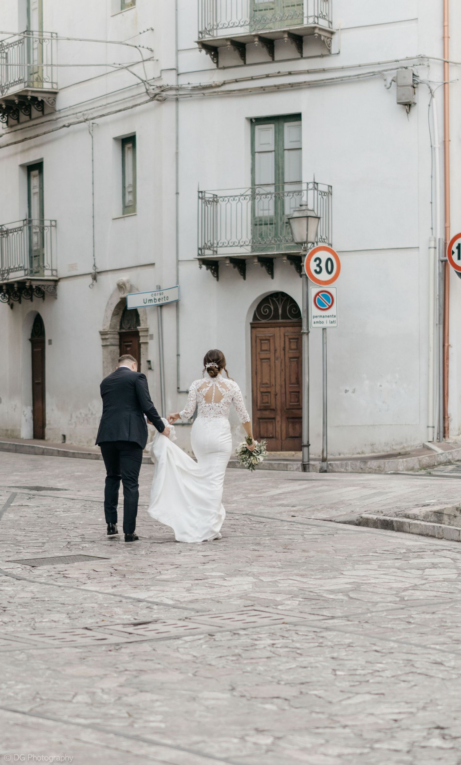 A panoramic series of wedding photos capturing a couple strolling through narrow European streets with white buildings.
