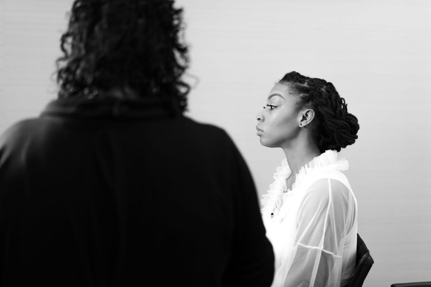 A black and white photo series showing various artistic portrait poses in dramatic lighting and shadows.
