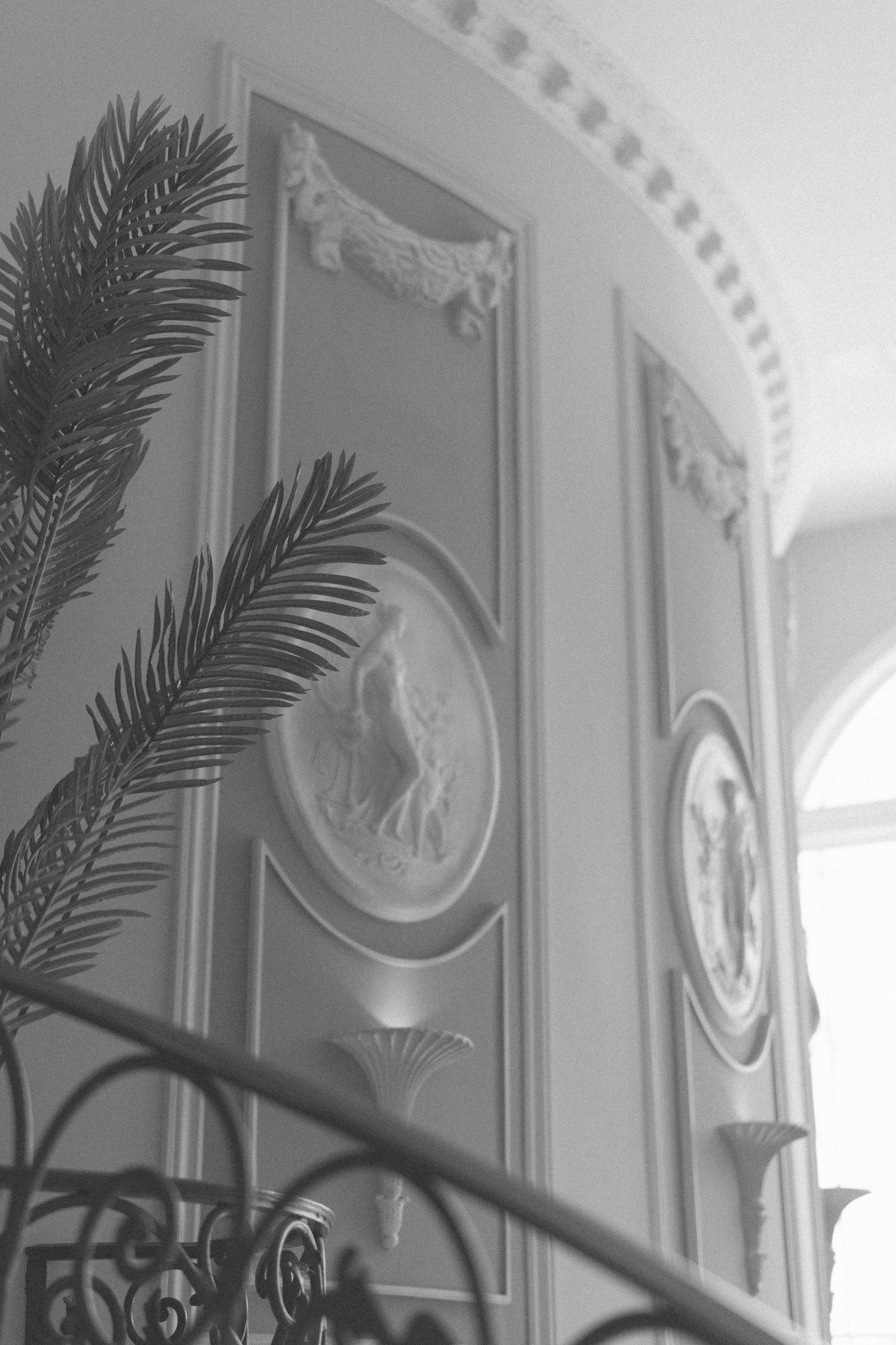 Elegant wall moldings with palm frond decorations in a classical interior.