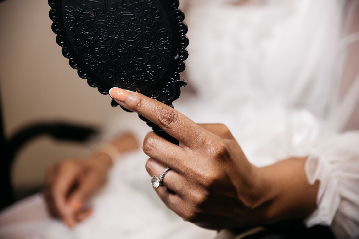 Close-up of hands holding a wedding ring during an intimate ceremony.