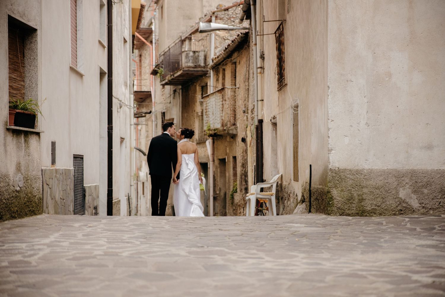 A narrow cobblestone street between old stone buildings in a European village with rustic charm.