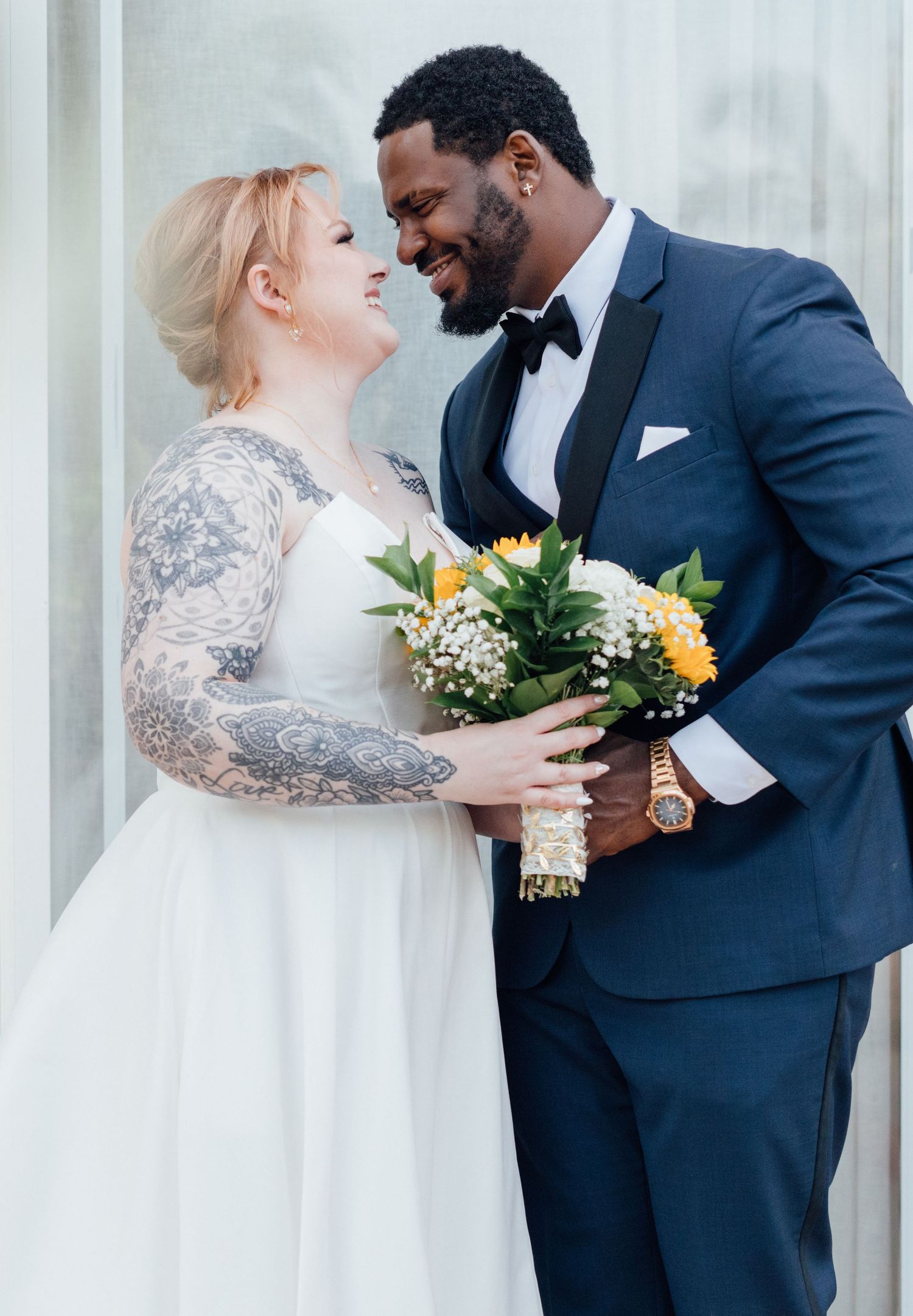 Romantic wedding portraits showing tender moments between newlyweds with sunflower bouquet.