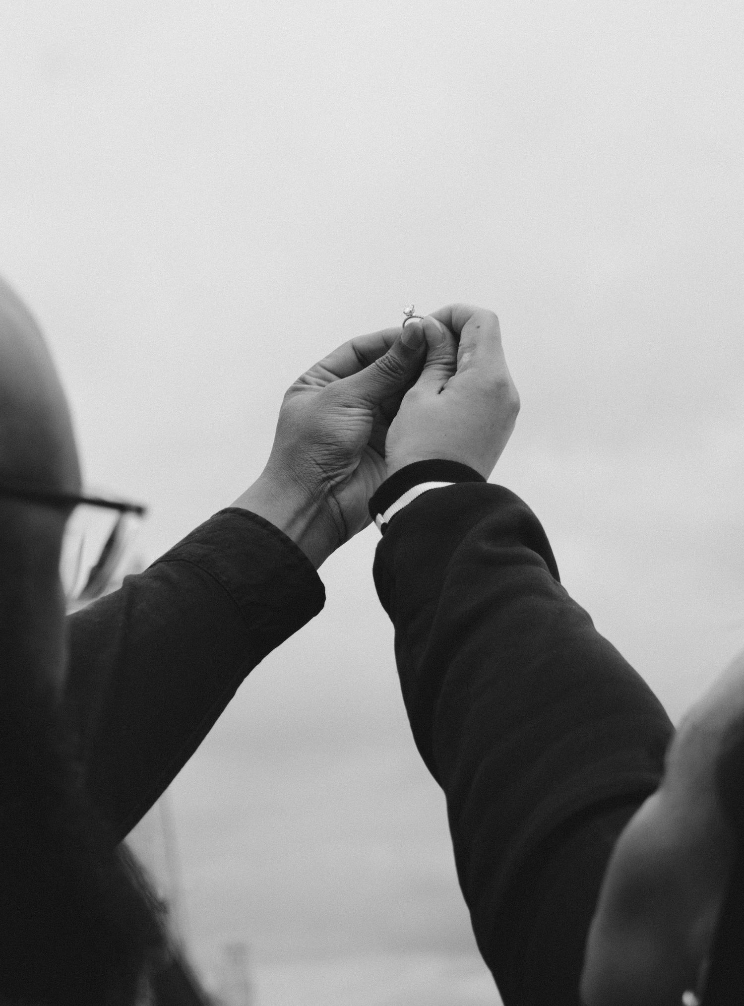 Black and white photo of hands carefully holding a ring.