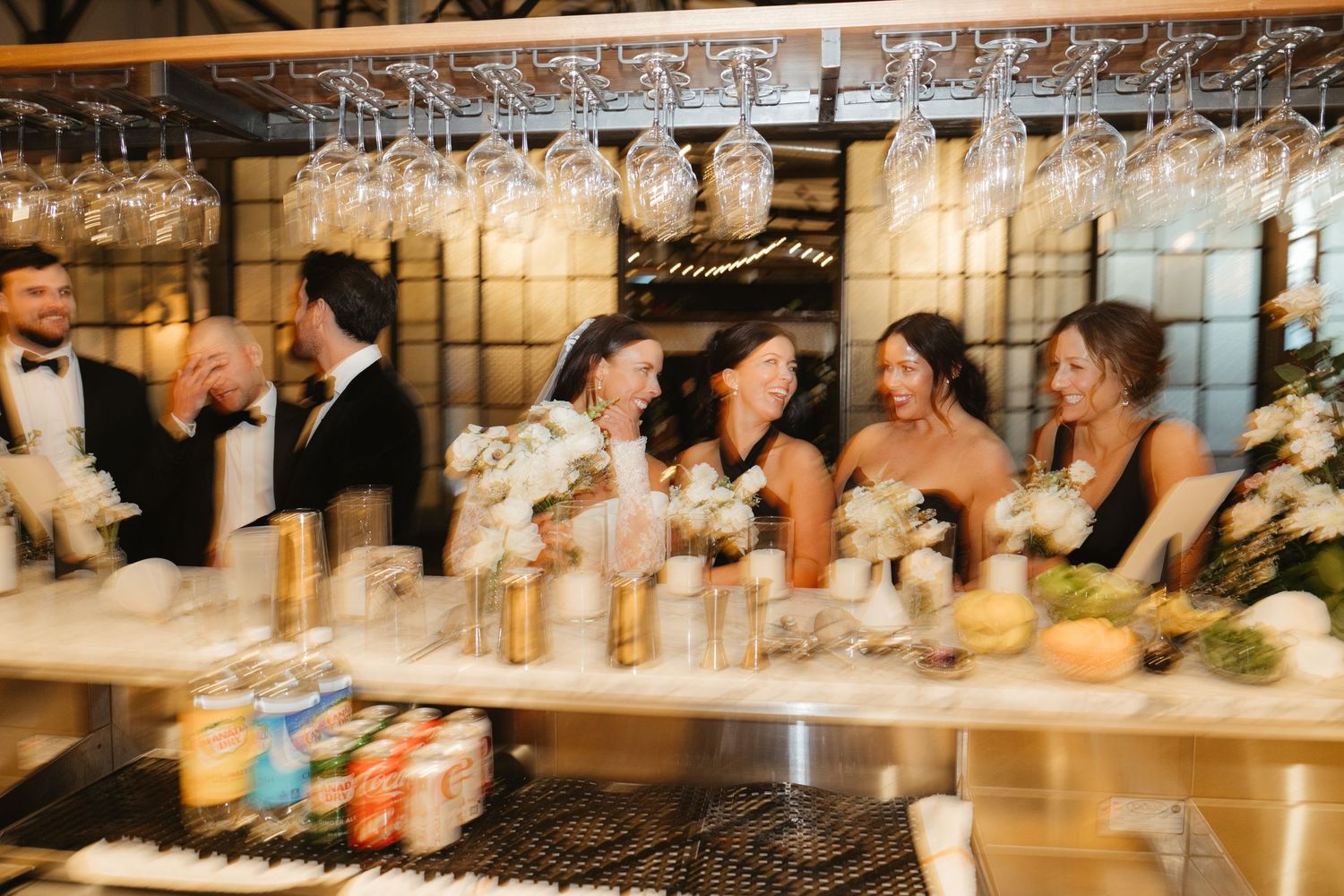 Motion-blurred celebration scene at elegant wedding reception bar.
