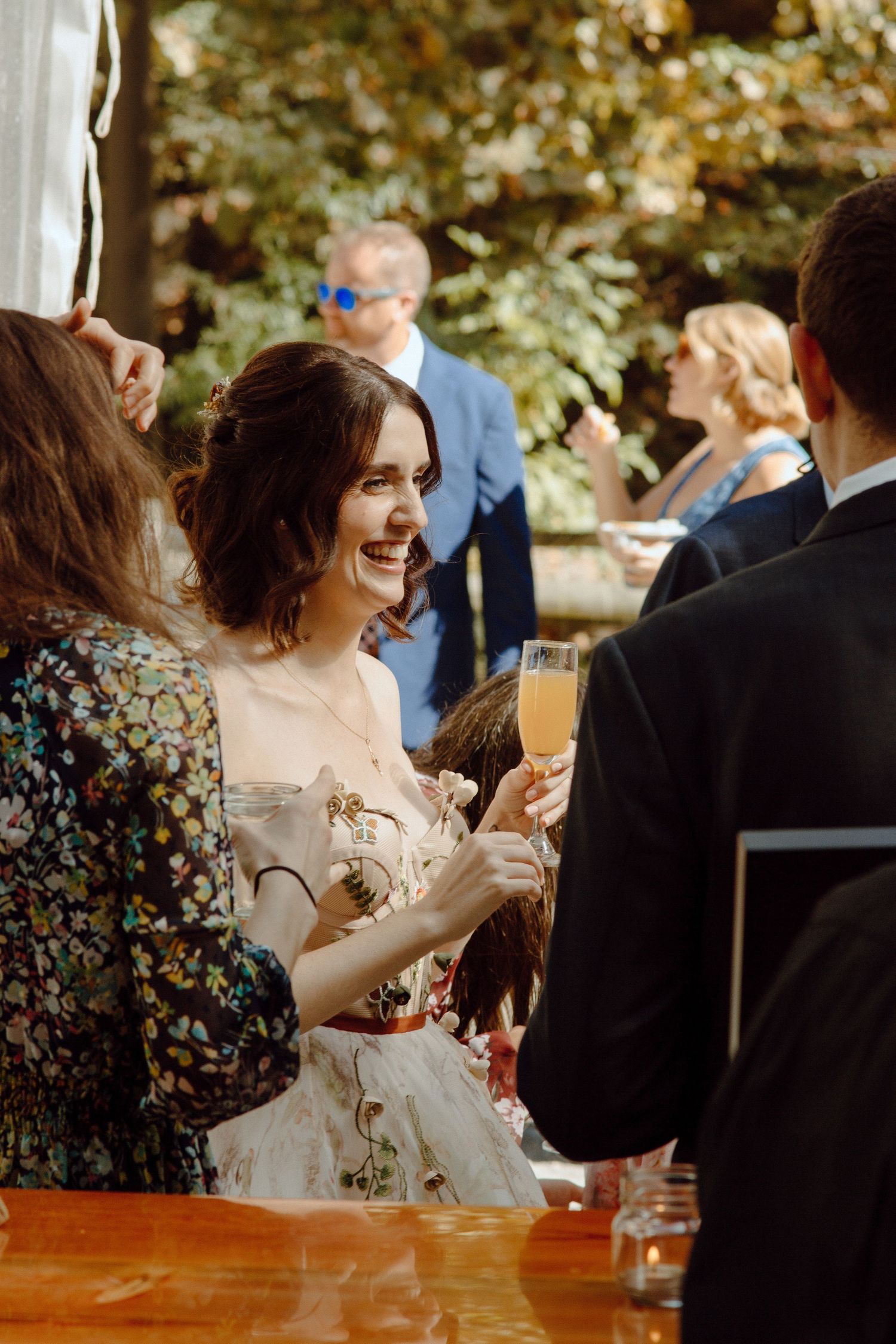 Wedding reception celebration with guests enjoying champagne in an outdoor garden setting.