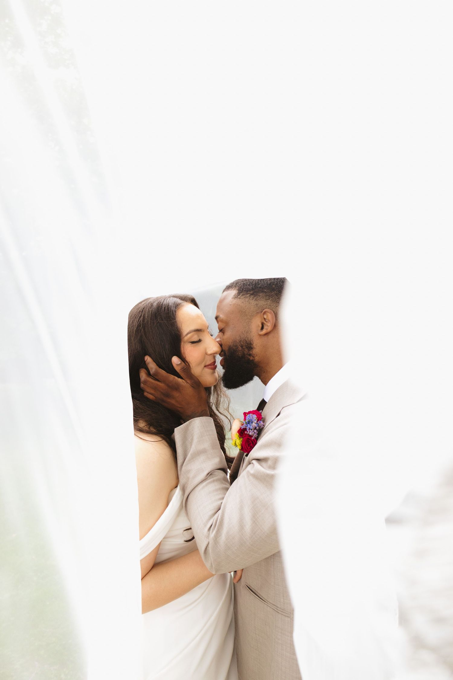 Three photos of a romantic wedding kiss between newlyweds in white attire against a light background.