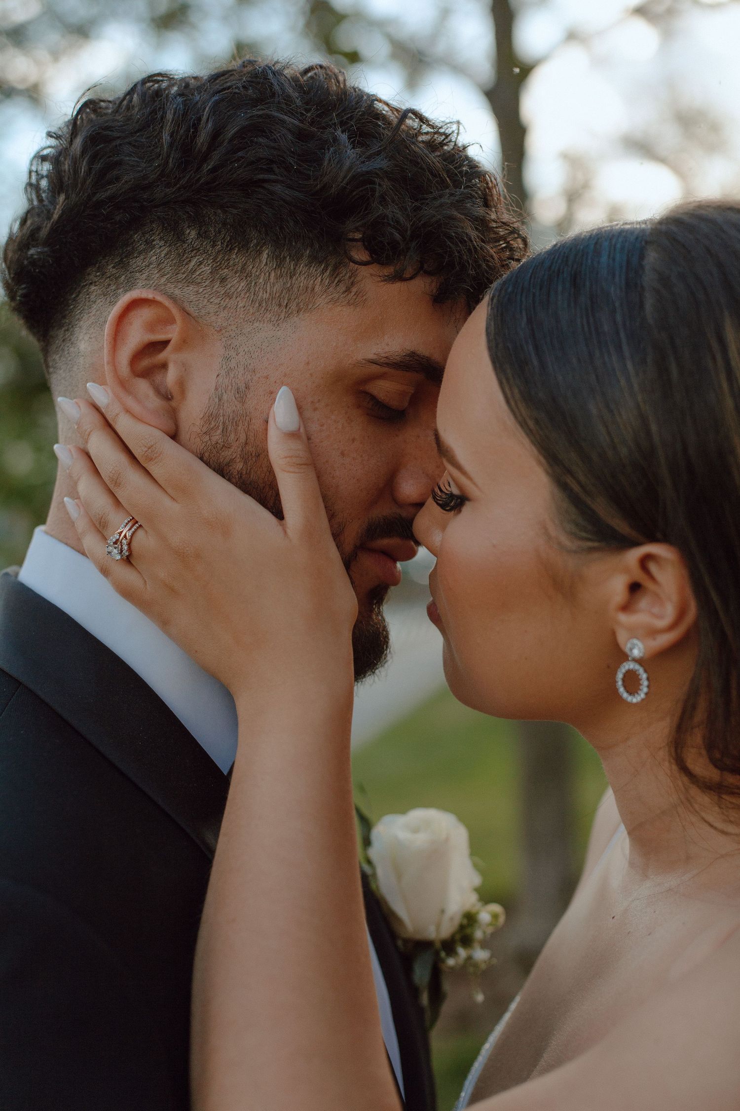 Intimate moment between newlyweds showing wedding ring and formal attire.