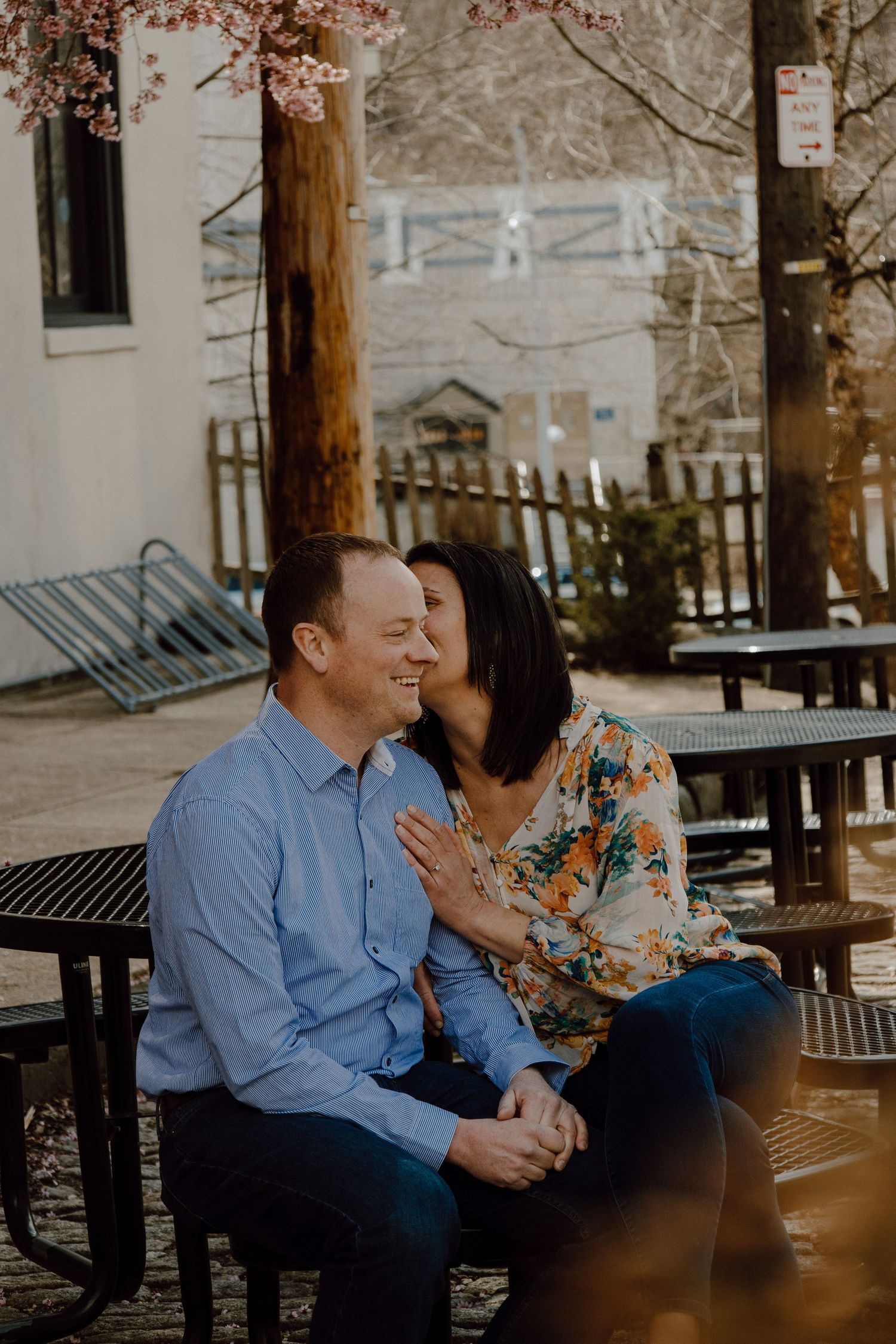 Couple sharing an intimate moment while sitting on a park bench on an autumn day.