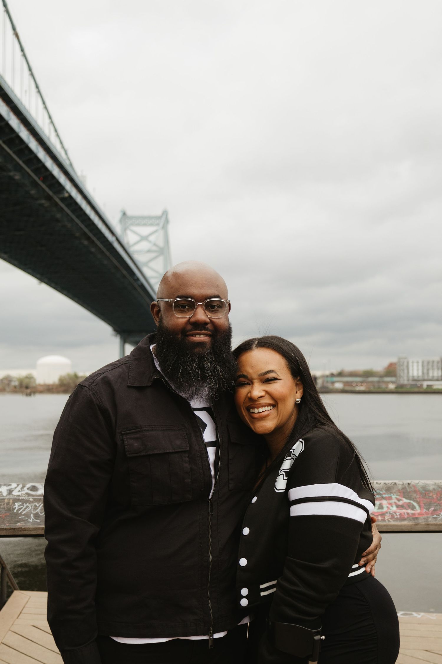 Happy couple sharing a moment together under the Benjamin Franklin Bridge in Philadelphia.