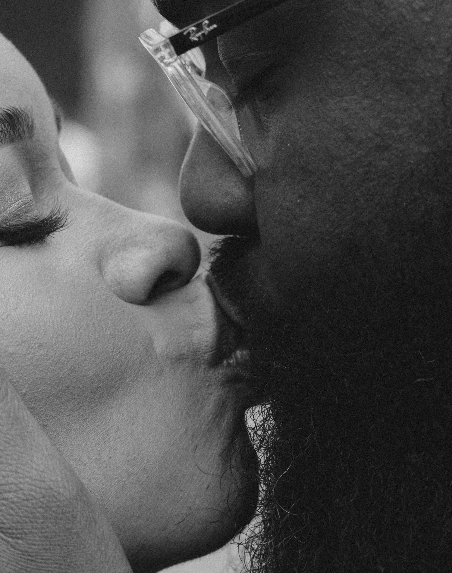 An intimate black and white close-up portrait of a romantic kiss.