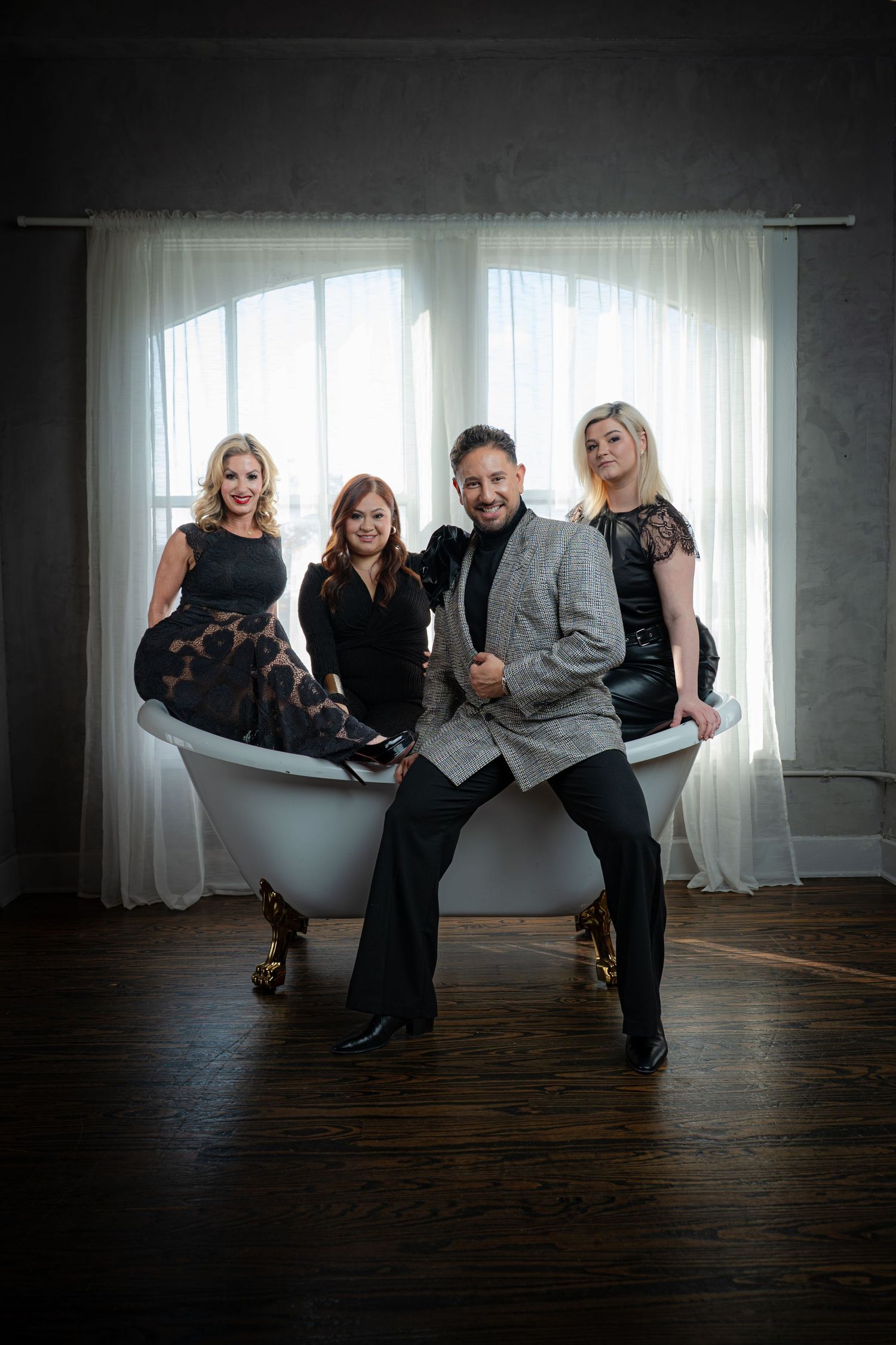 A stylish group poses playfully in an artistic photo sequence against a dark backdrop with white curtains.