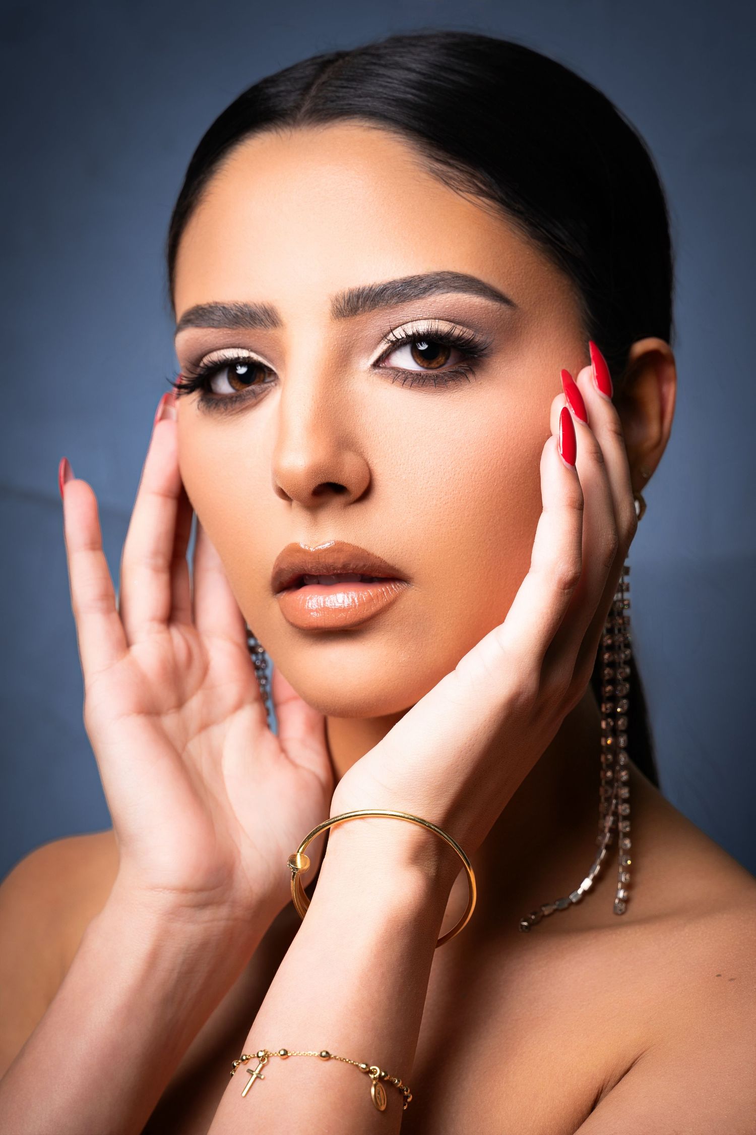 A series of artistic close-up beauty portraits showing hands framing the face with dramatic lighting and red nails.