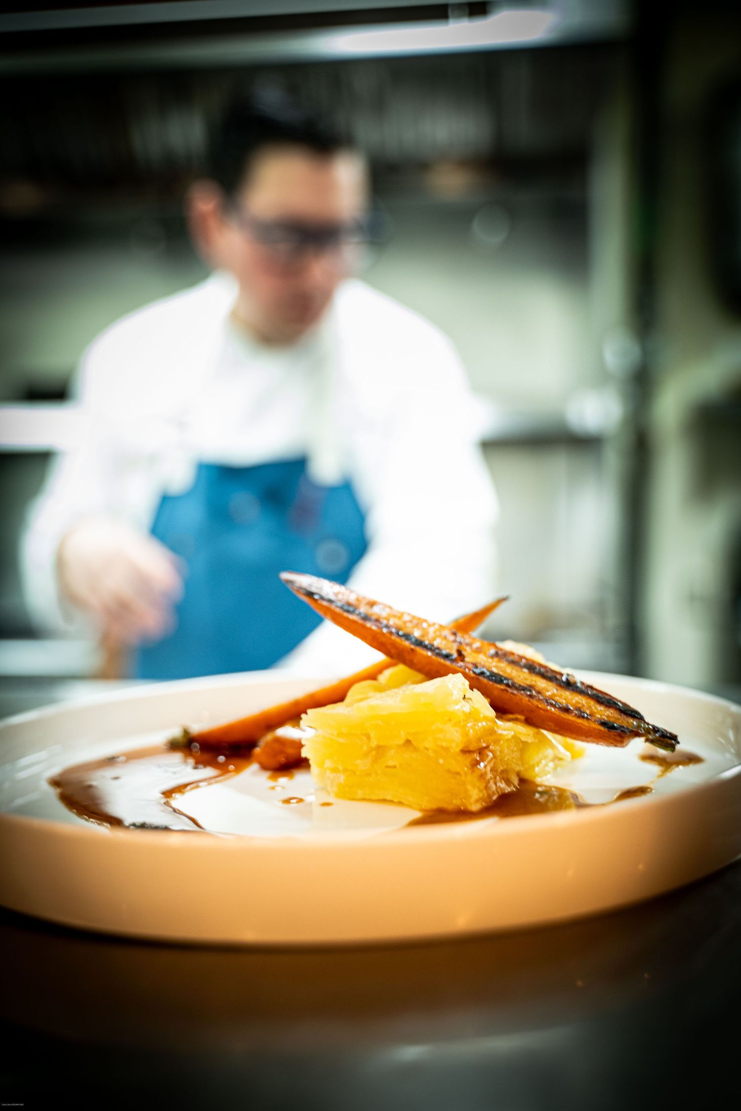 Close-up of plated dessert with citrus segments and chocolate garnish on white dish in restaurant setting.