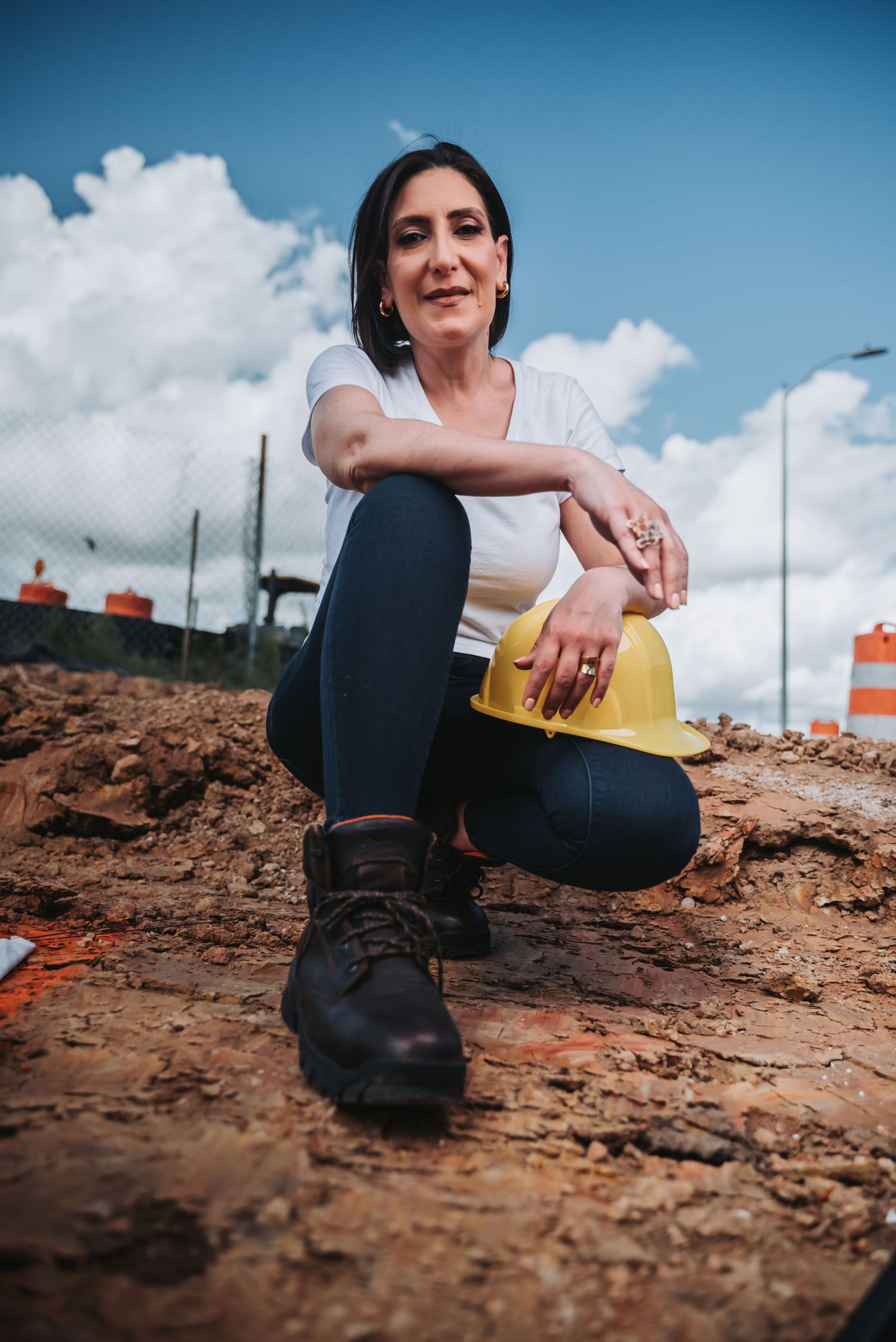 Professional posing at a construction site in Houston, wearing safety gear and work attire