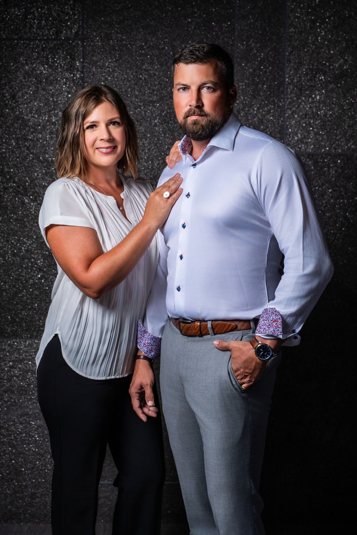 Professional photo series of two people in business attire against dark textured background.