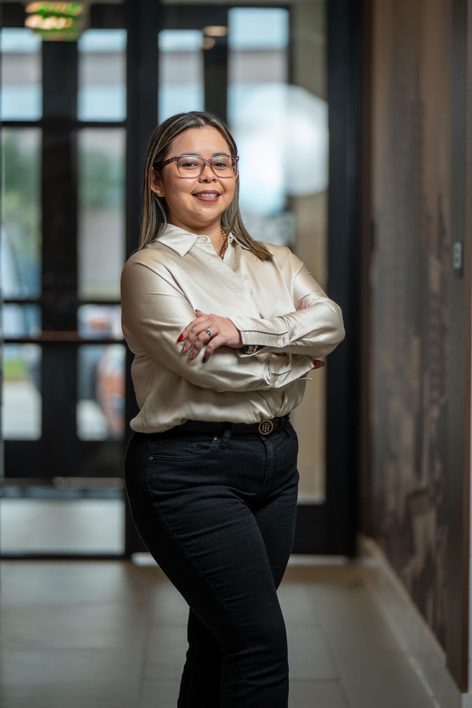 Lifestyle portrait of a health and life insurance professional in Houston, Texas, posing on a bench in an office setting with earthy tones