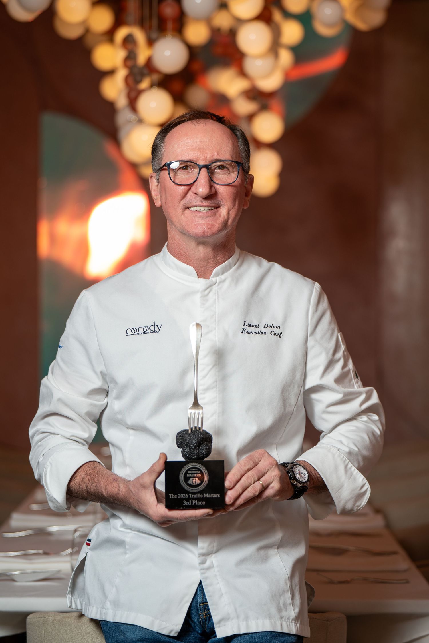 Chef Lionel Debon holding the third-place Truffle Masters award at Cocody restaurant in Houston, Texas.