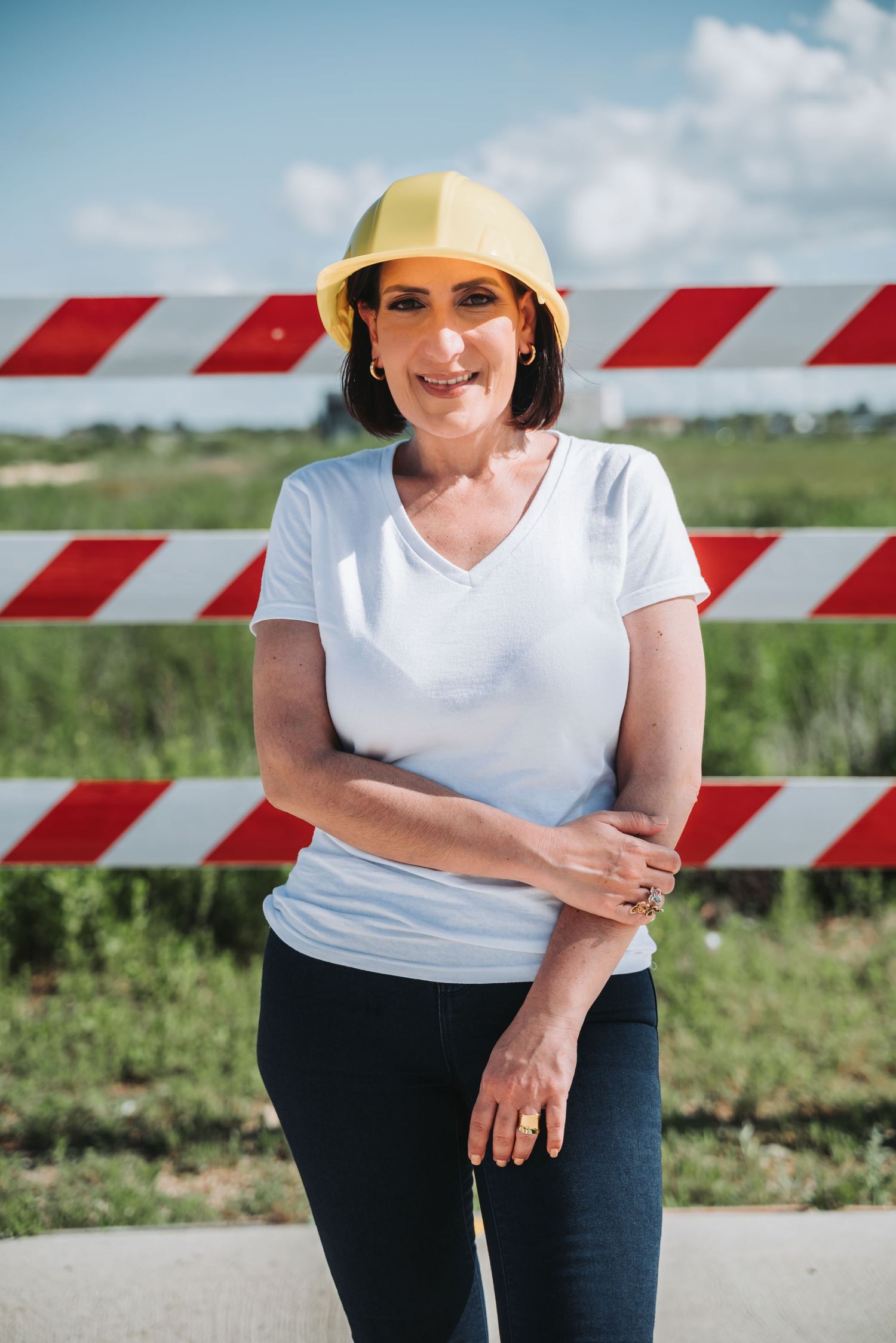 Professional posing at a construction site in Houston, wearing safety gear and work attire