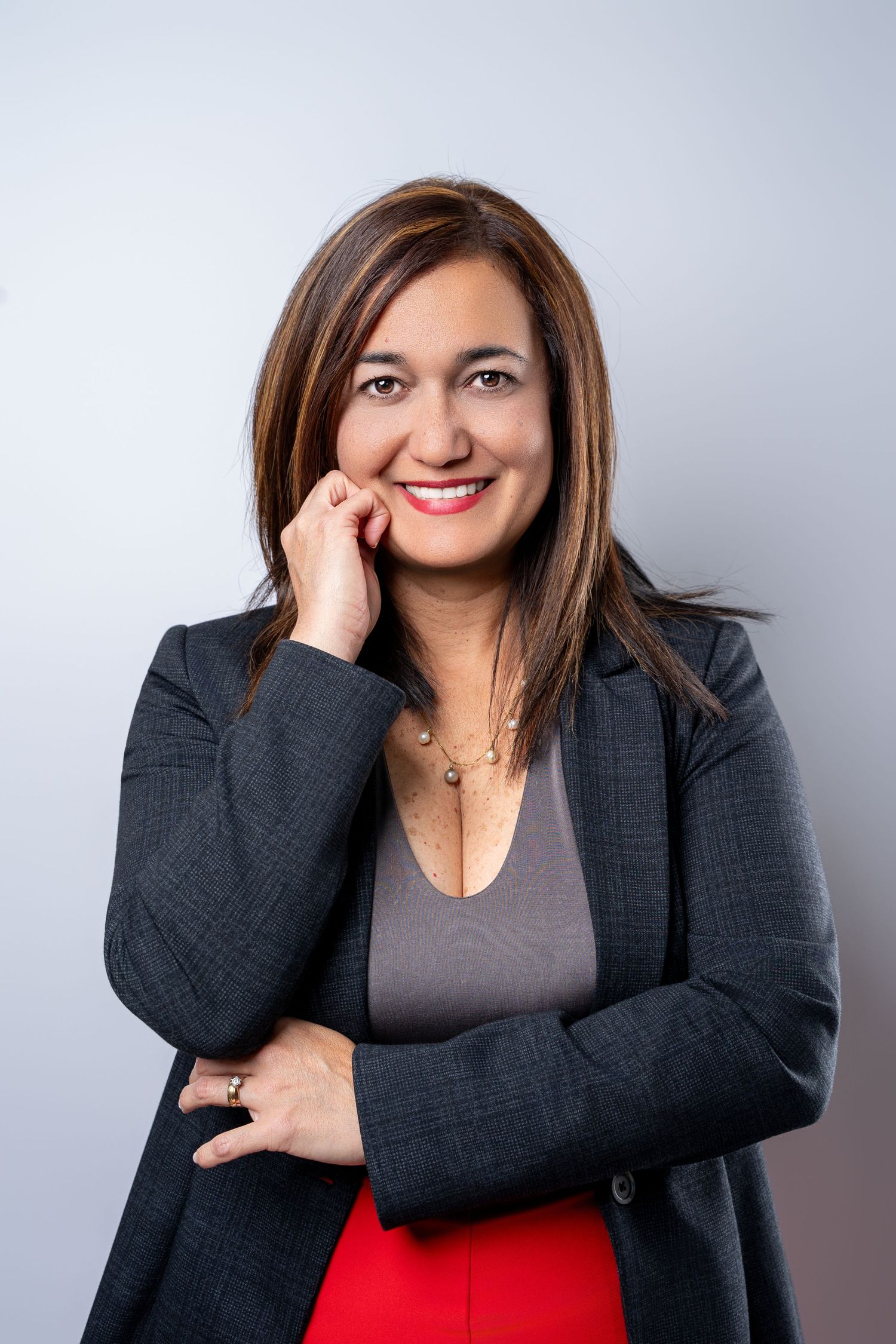 Professional headshot photos showing confident poses in business attire against a light gray studio background.