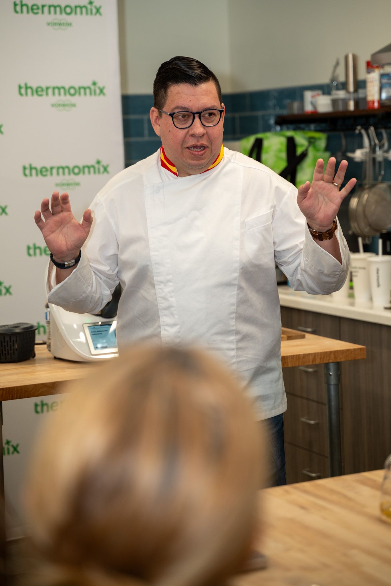 Professional chef teaching a culinary class in Houston, Texas, captured in action while engaging with students. Ideal for showcasing experti