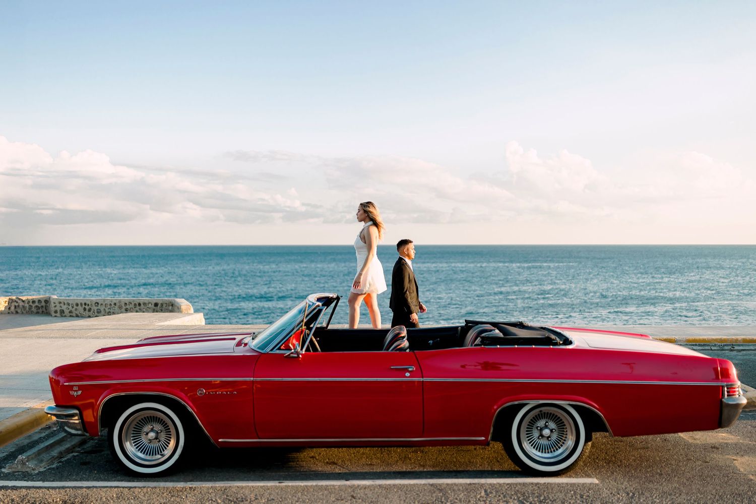 Vintage red Chevrolet convertible photo shoot by the ocean.