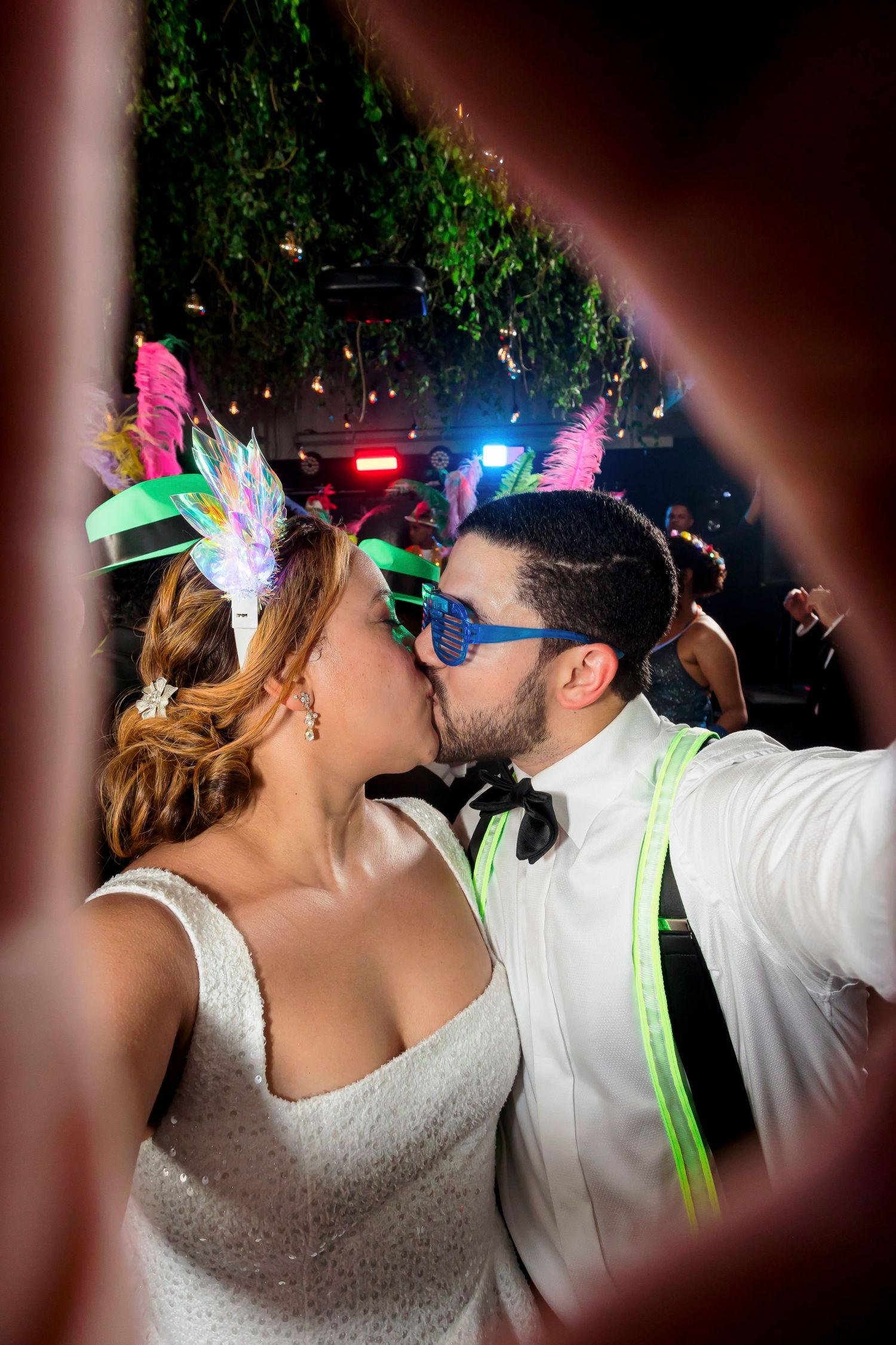 Dancing couple at reception wearing LED accessories and festive party attire.