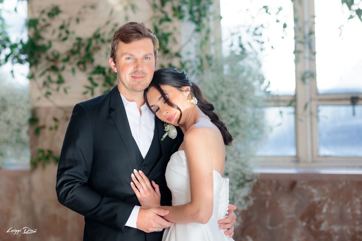 Romantic wedding portrait in front of large windows with natural light.