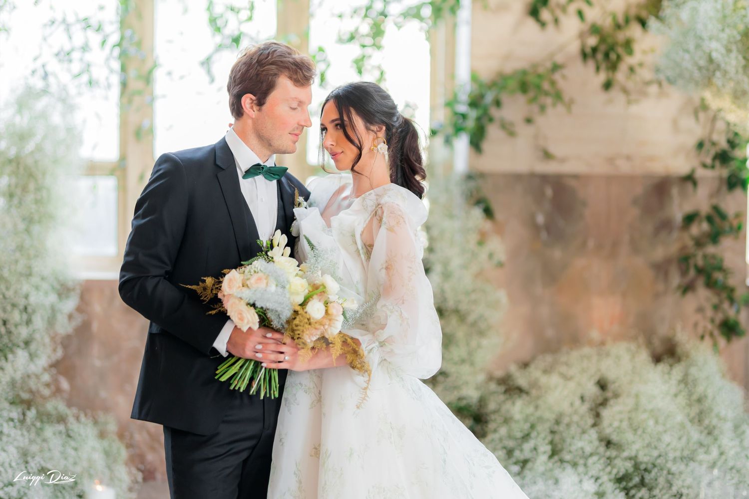Elegant wedding portrait with natural light streaming through large windows.