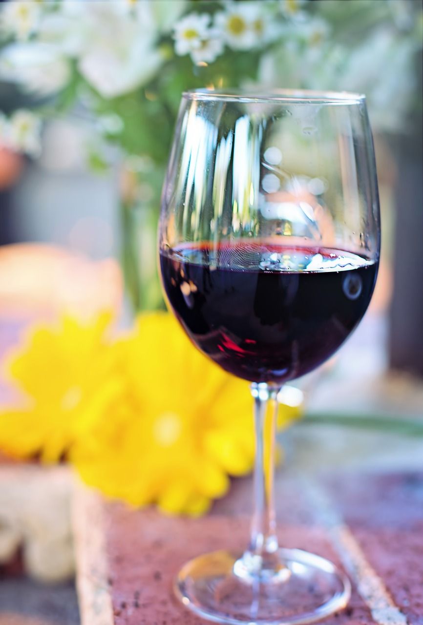 Photo d'un verre de vin rouge sur une table avec des fleurs