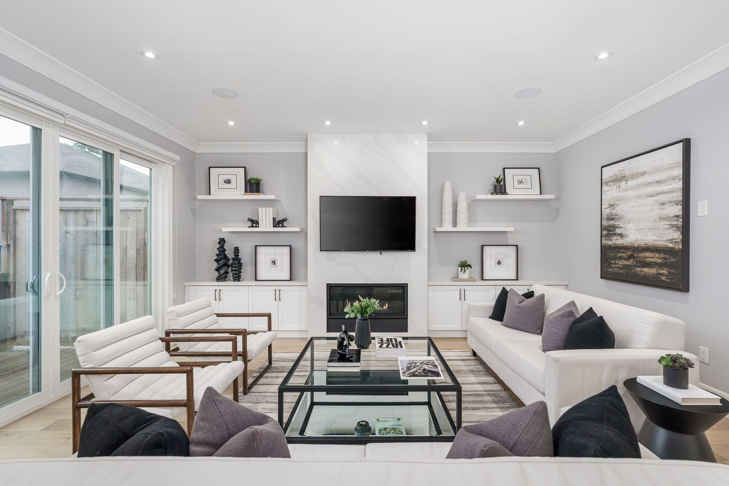 Modern open concept living room showcases neutral decor with white walls, grey furniture, and built-in storage solutions.