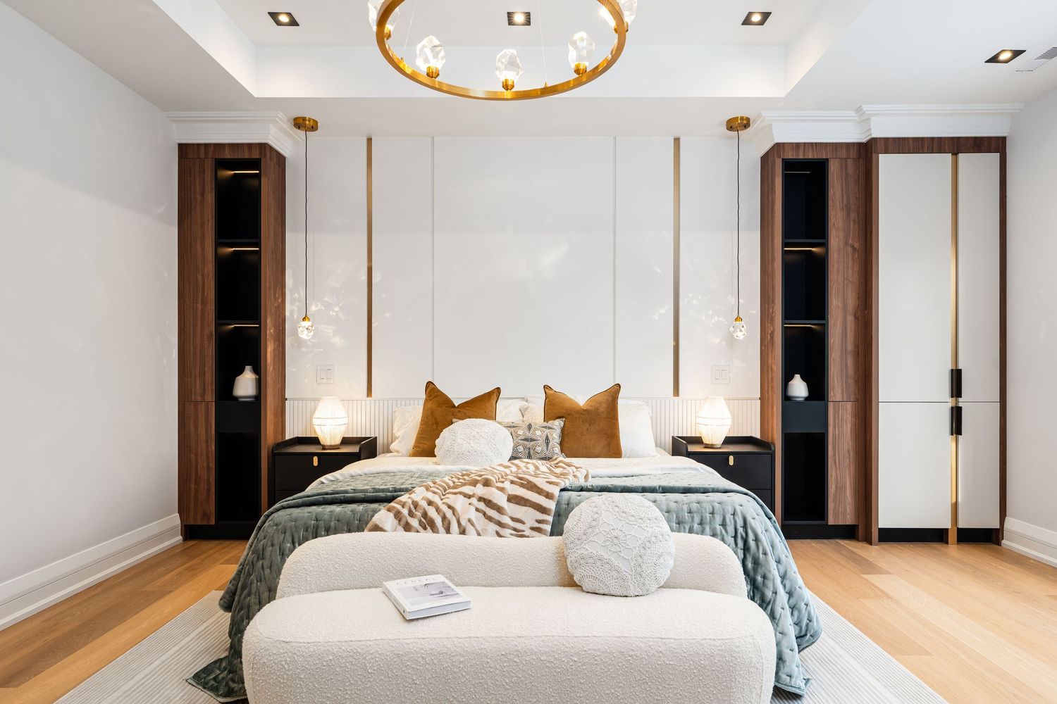 Modern bedroom with white walls, wood accents, and minimalist pendant lighting fixtures.