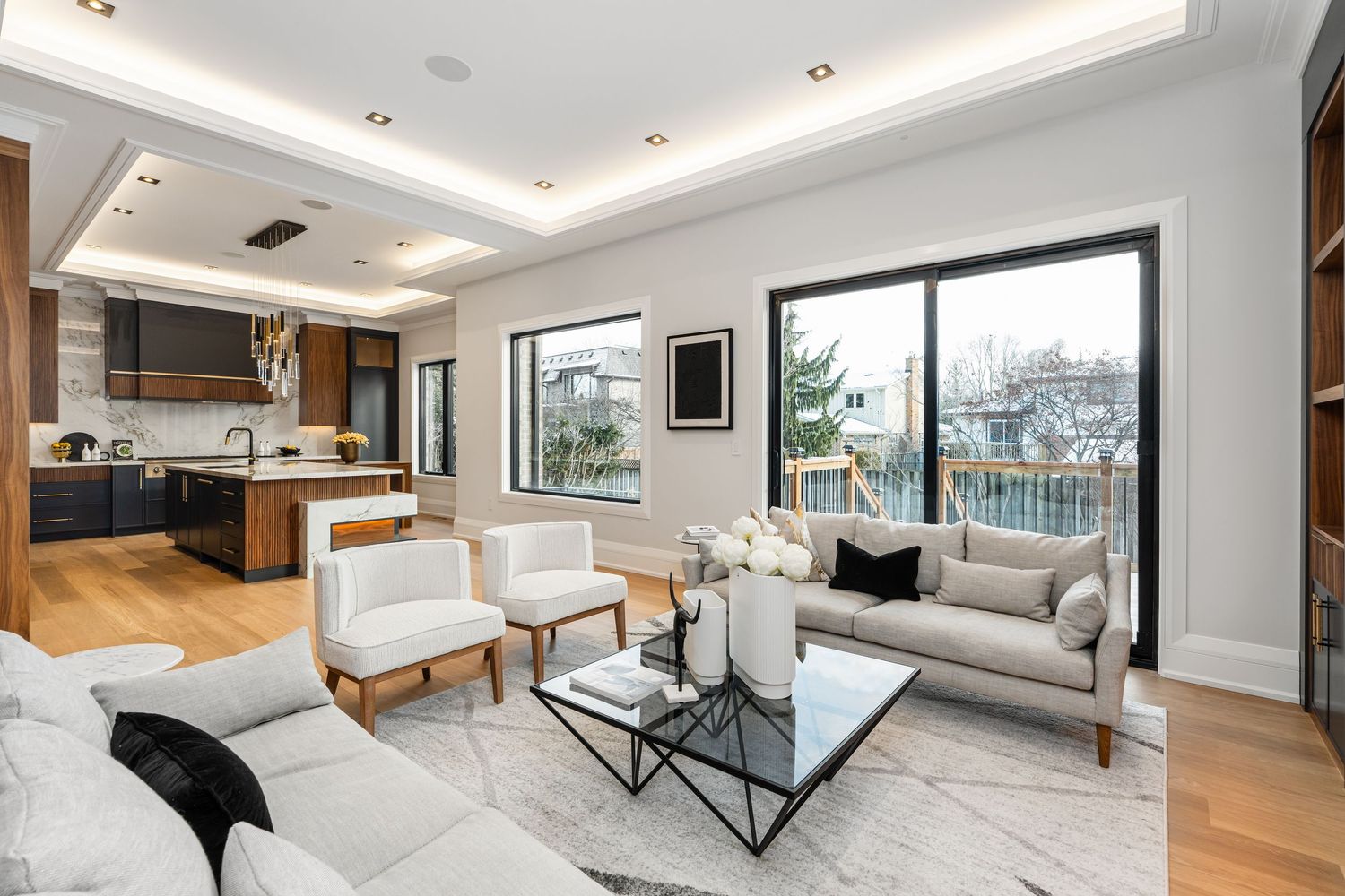 Contemporary living area with panoramic windows, white sectional sofa, and minimalist decor.