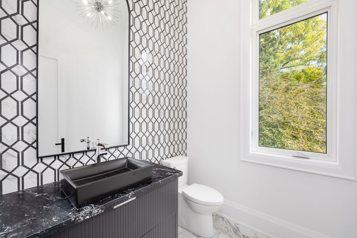 White bathroom with geometric pattern wallpaper and modern window design.