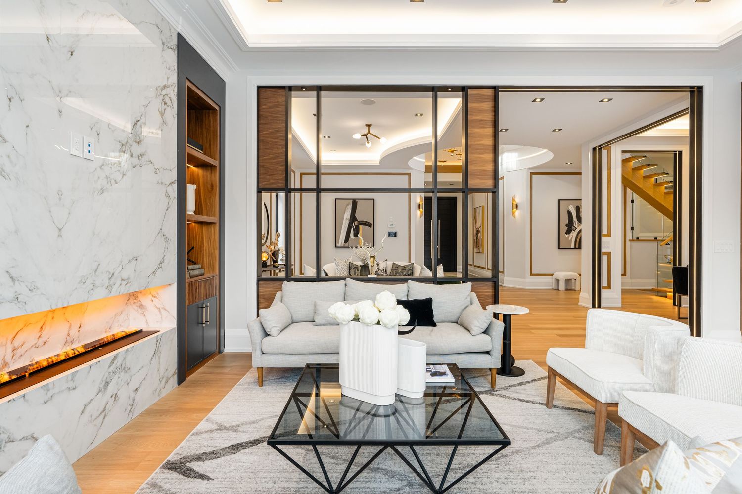Upscale living room featuring marble walls, geometric coffee table, and plush white seating.