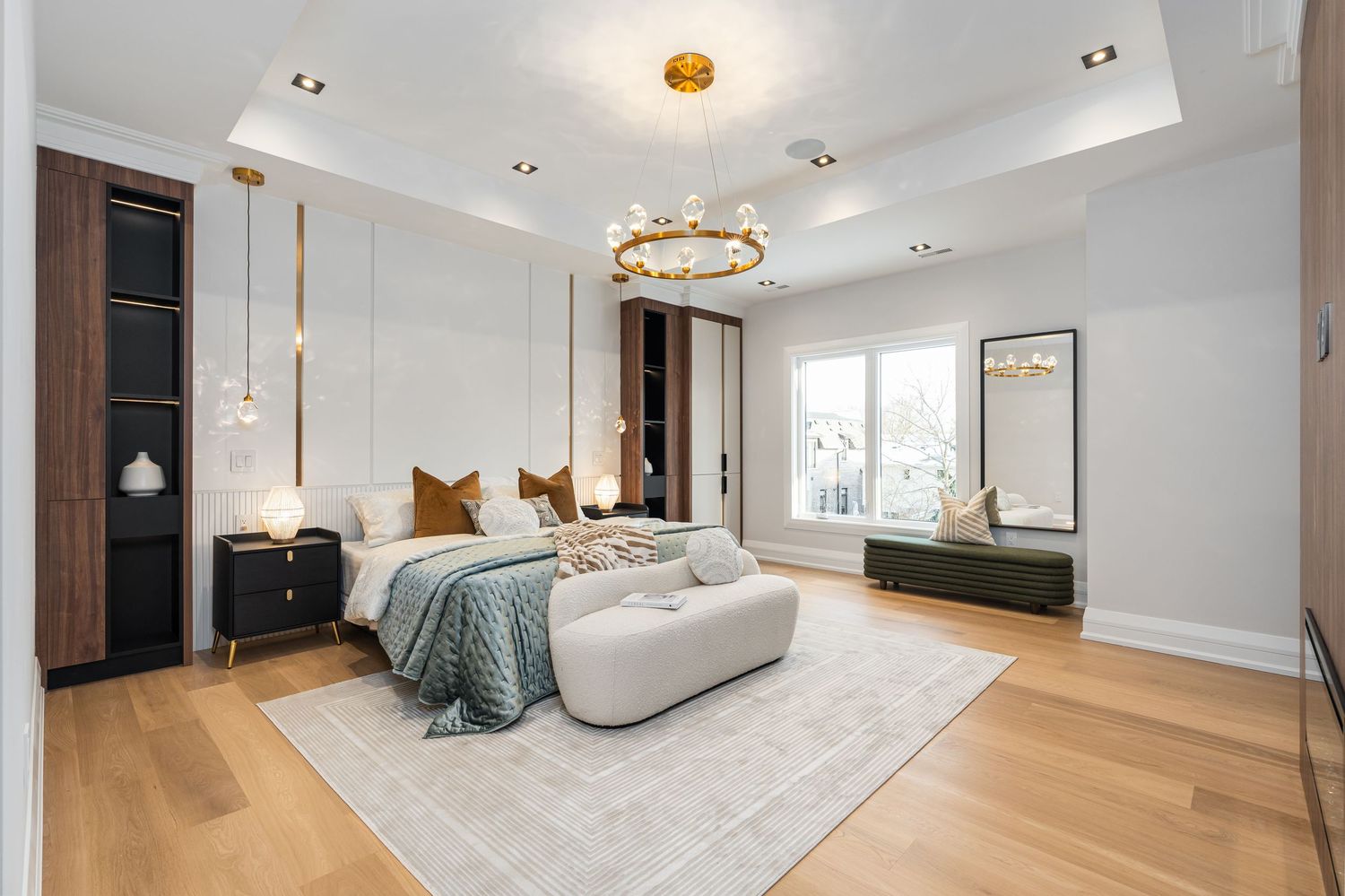 Contemporary master bedroom with ring chandelier, built-in storage, and floor-to-ceiling windows.