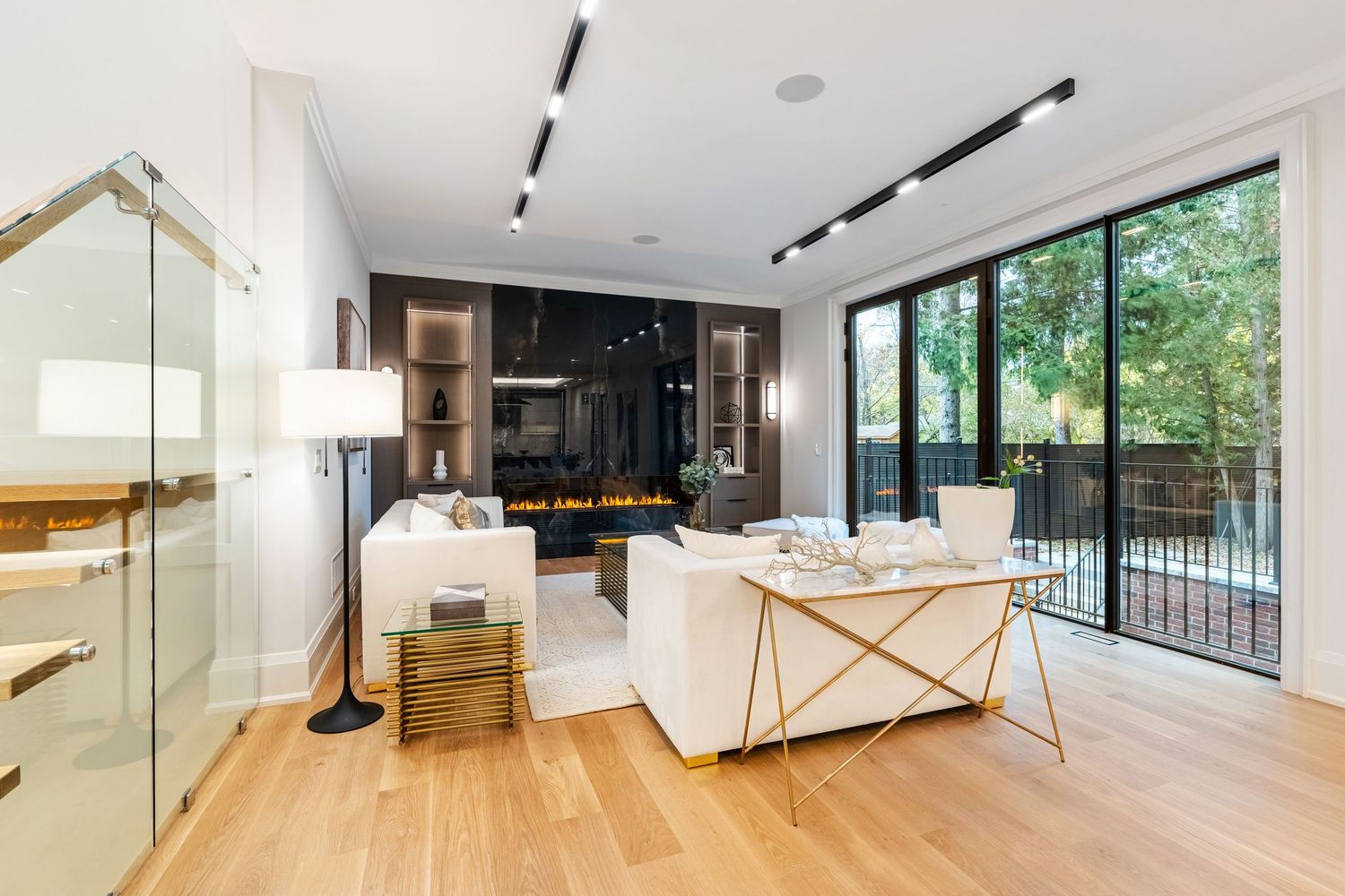 Bright open floor plan living space with floor-to-ceiling windows and hardwood flooring.