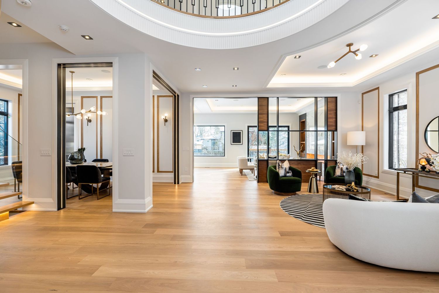 Spacious modern open-concept living area with hardwood floors and circular skylight.