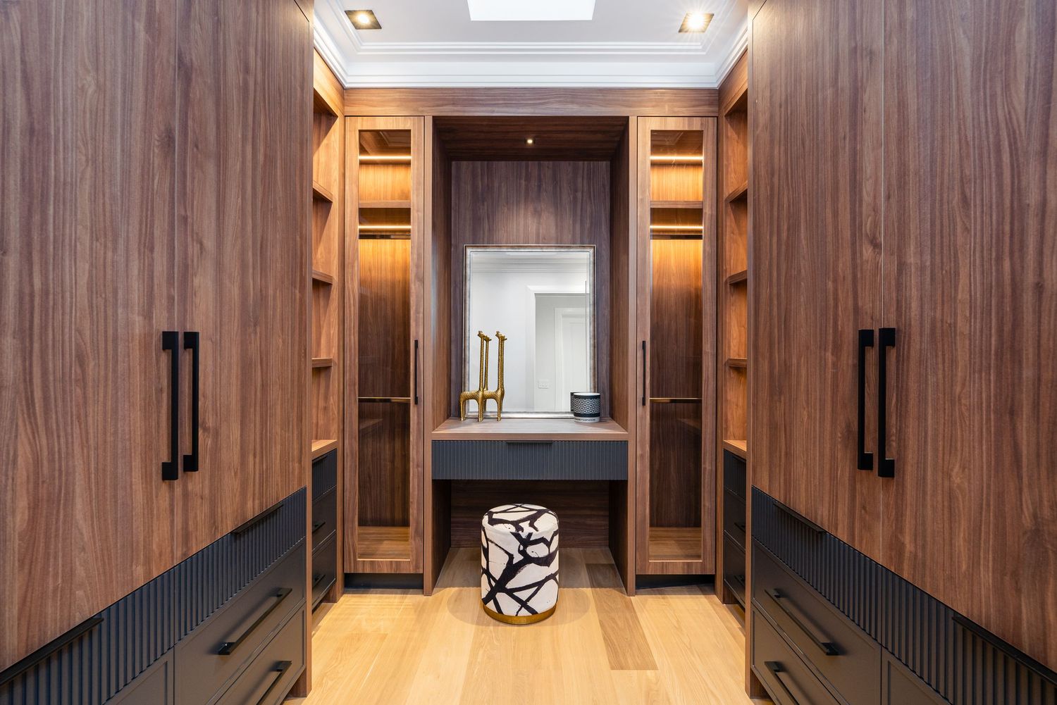 Elegant hallway with dark wood built-in storage and recessed lighting.