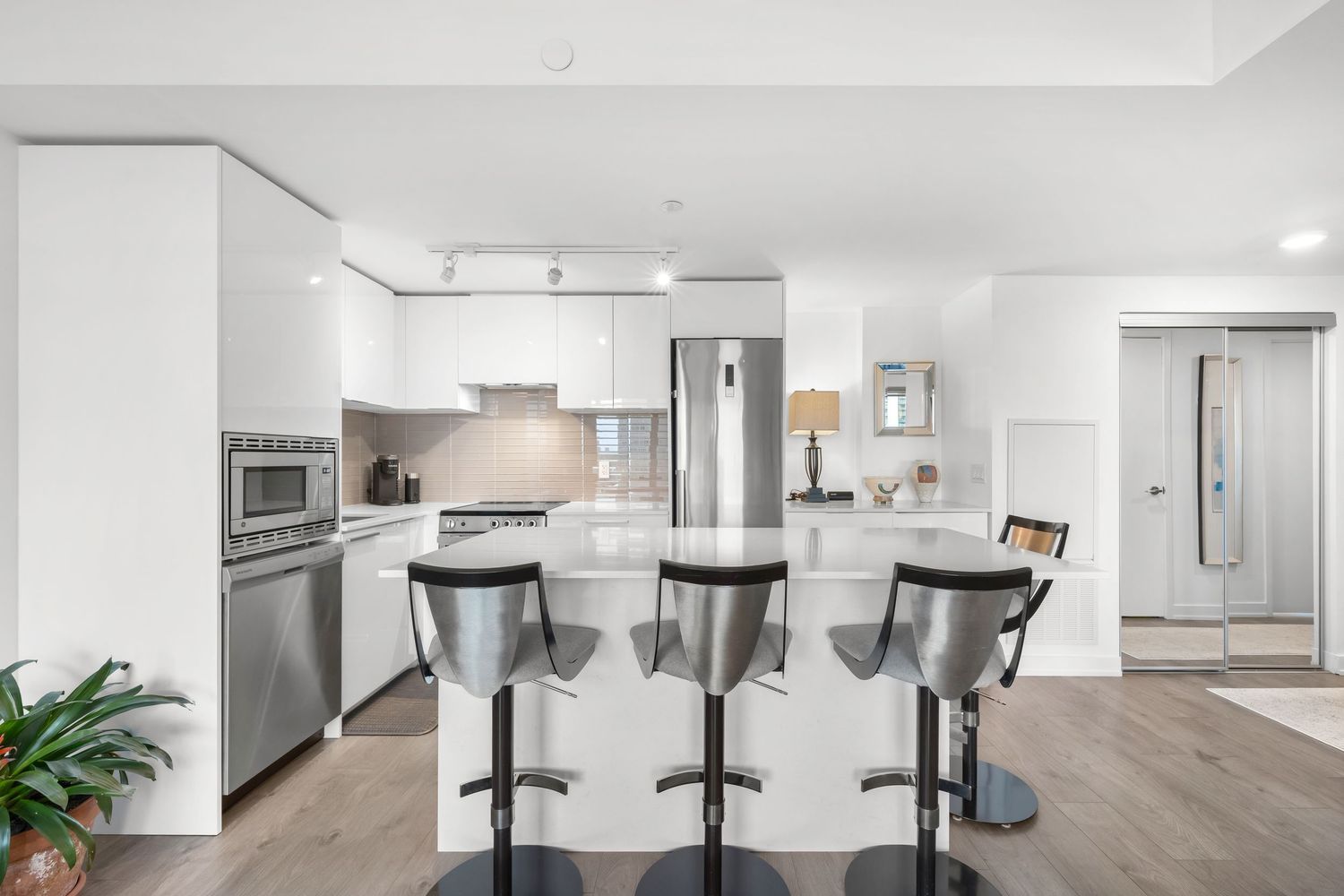 luxury kitchen interior with bright white walls, hardwood floors and sleek glass meeting rooms showcasing a minimalist design.