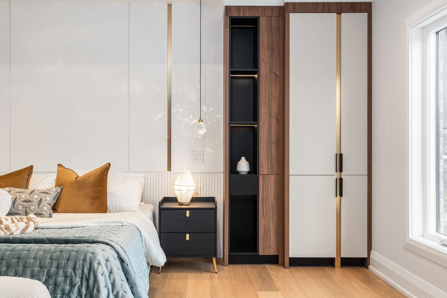 Contemporary bedroom featuring built-in wood cabinetry and teal accent bedding.