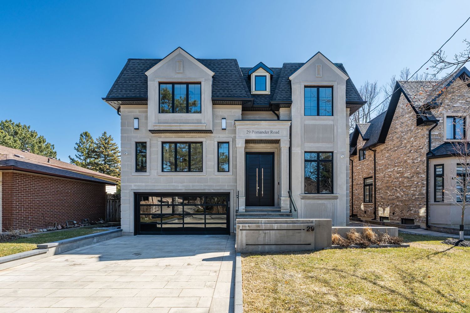 Luxury homes with modern architectural design showcasing stone facades and black trim details.