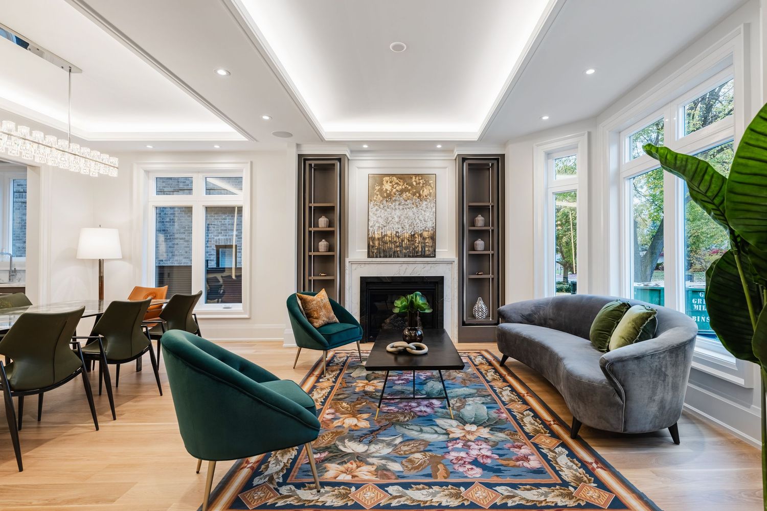 Modern living room with teal accent chairs, patterned rug, and bright white walls.