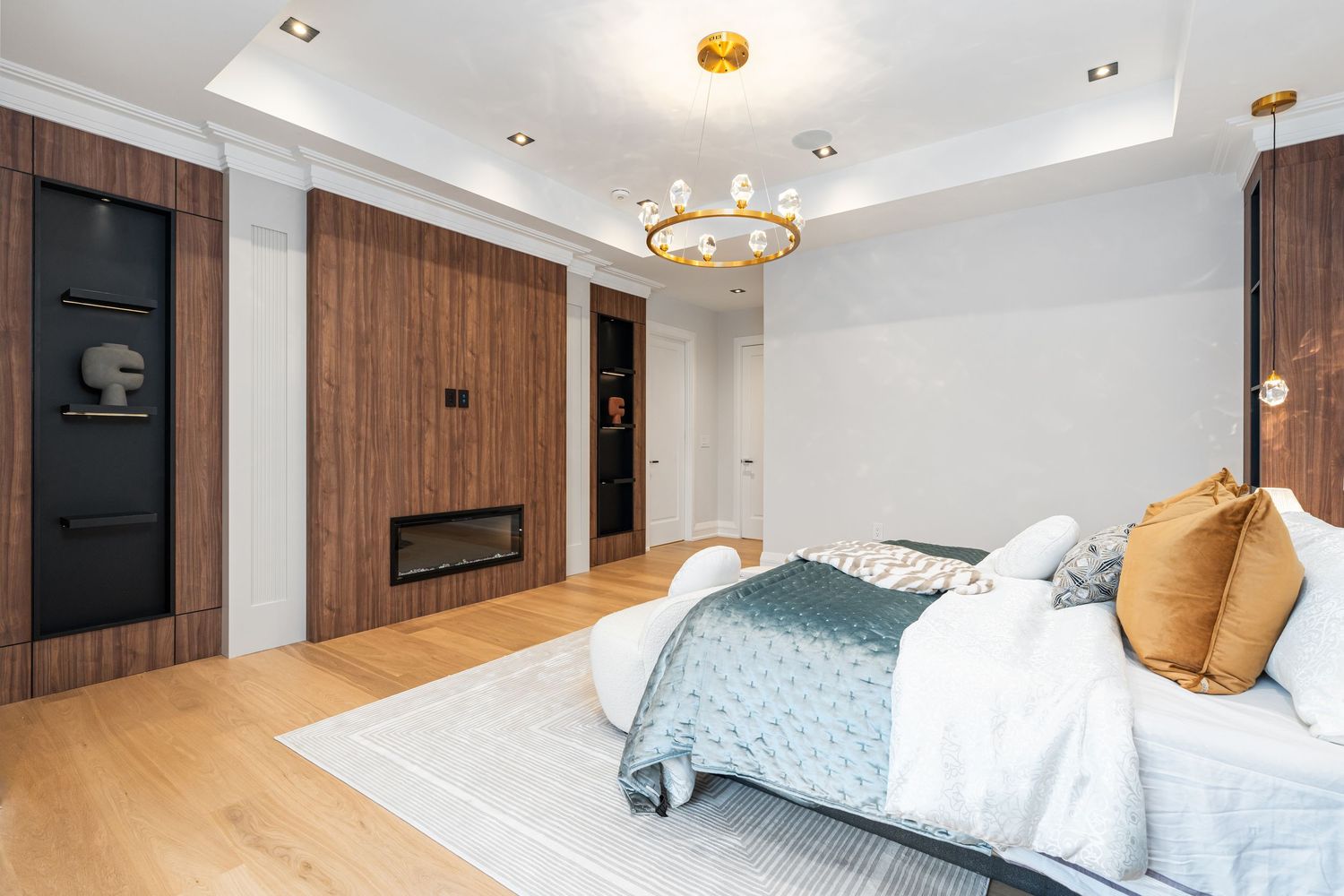 Luxurious master bedroom with wooden wall panels and gold lighting fixtures.
