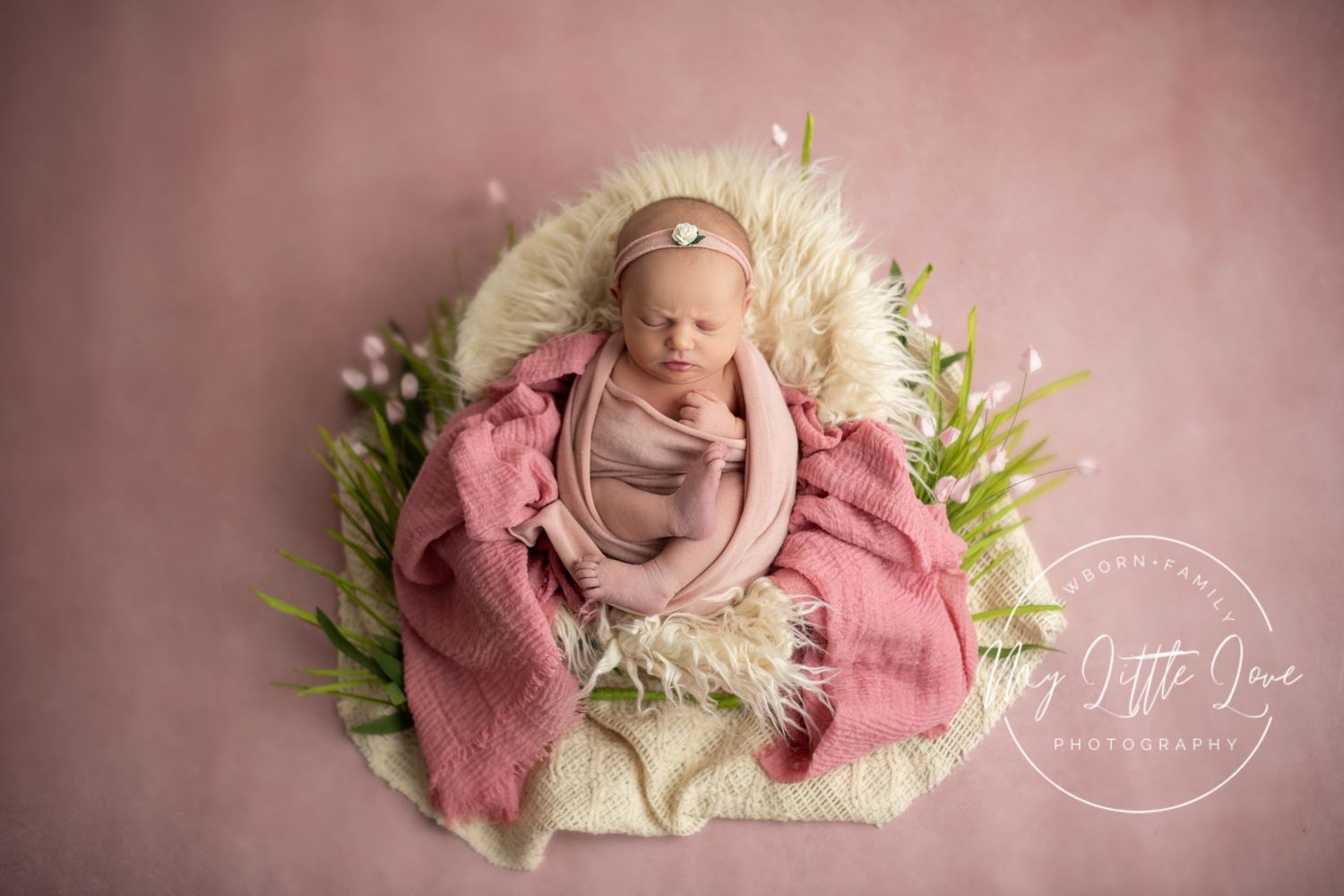 A series of soft pink newborn photography portraits with floral arrangements and cozy white blankets.