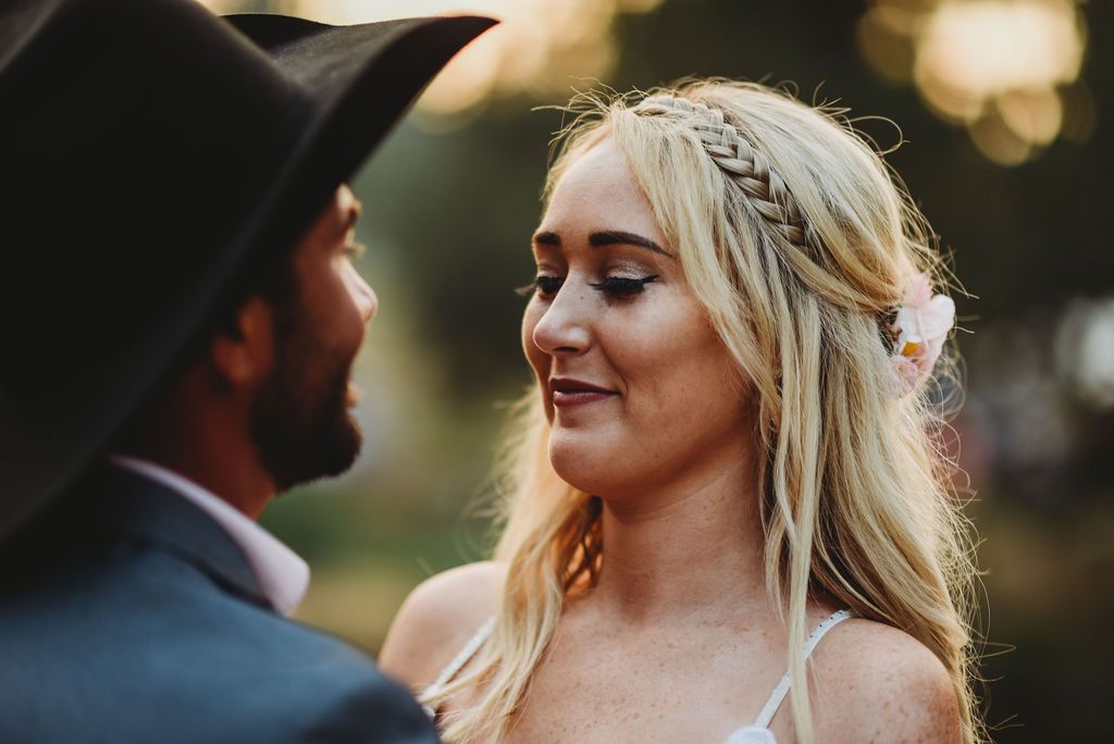 Close up of a couple sharing an intimate moment during their wedding ceremony at sunset.