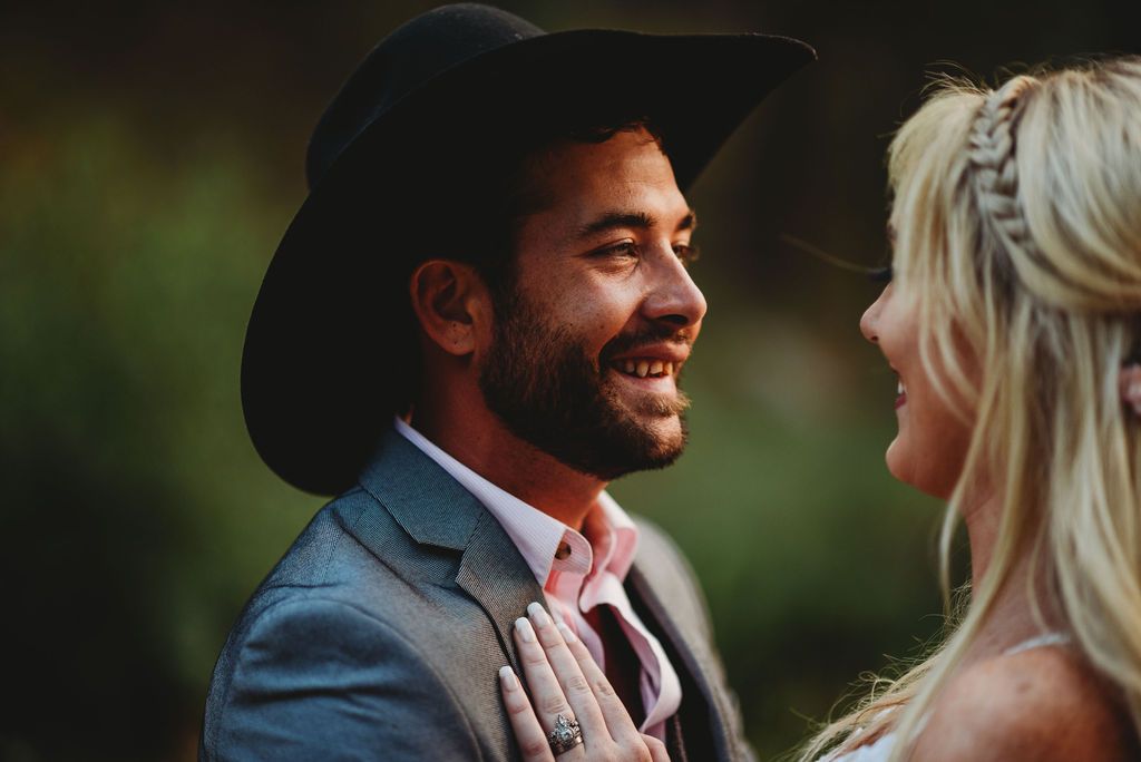 Joyful candid portrait of couple sharing a tender moment outdoors.