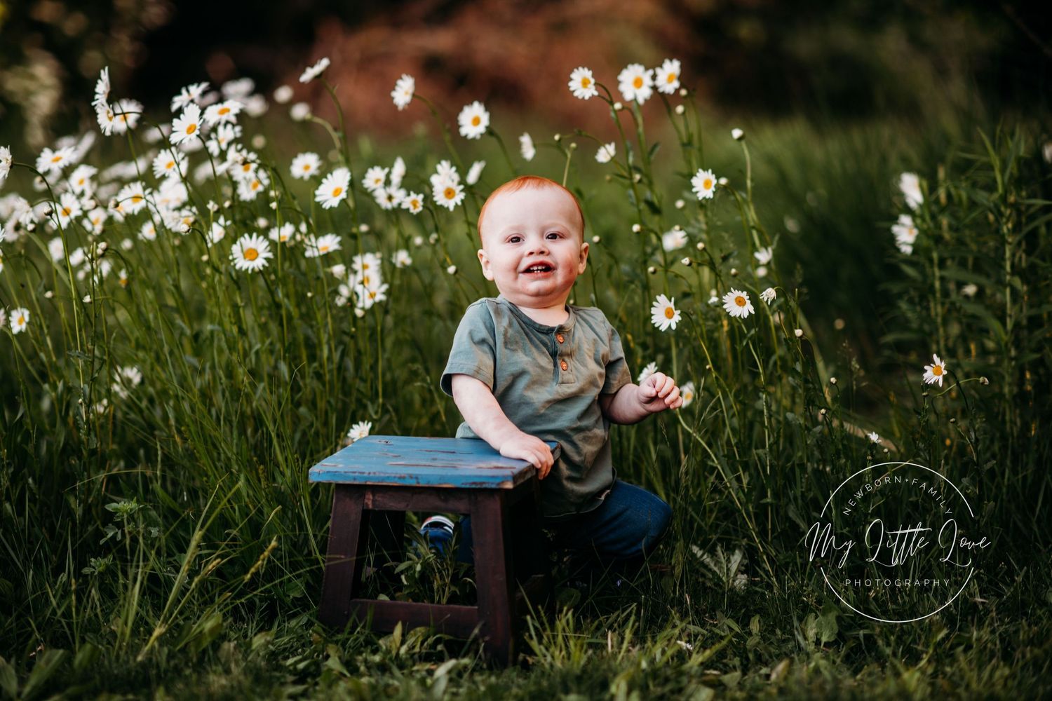 A candid portrait in a wildflower meadow with daisies and a wooden stool.