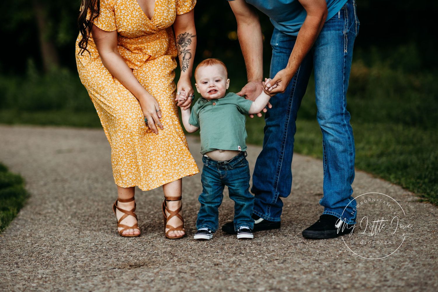 Family walking together outdoors showing legs and feet on concrete path.