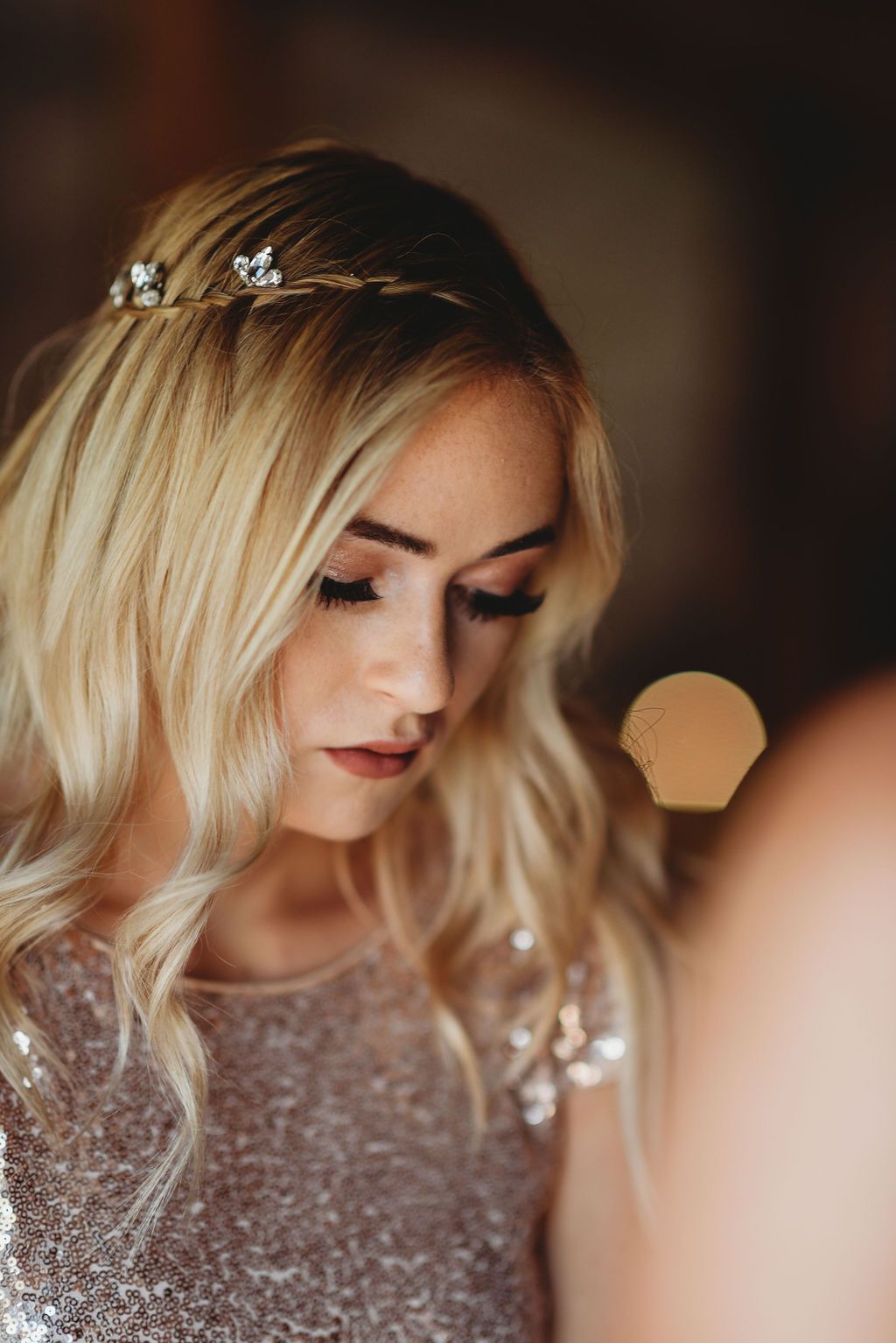 Close up of blonde hair adorned with delicate crystal hair accessories and sparkly dress details.